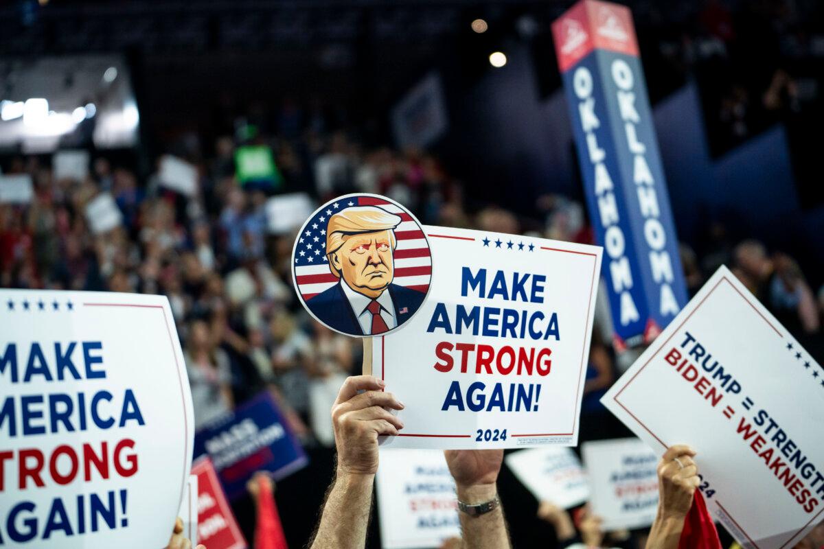 Delegates hold signs during the Republican National Convention (RNC) in Milwaukee, Wis., on July 17, 2024. (Madalina Vasiliu/The Epoch Times)