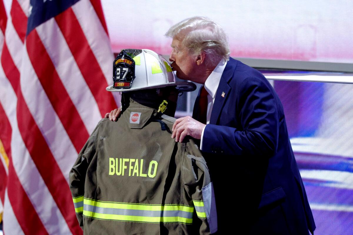 Former President Donald Trump kisses a helmet and firefighter's jacket that belonged to Corey Comperatore, who was fatally shot at a rally where Trump survived an assassination attempt, as he accepts his party's nomination on the last day of the 2024 Republican National Convention at the Fiserv Forum in Milwaukee, Wis., on July 18, 2024. (Kamil Krzaczynski/AFP via Getty Images)