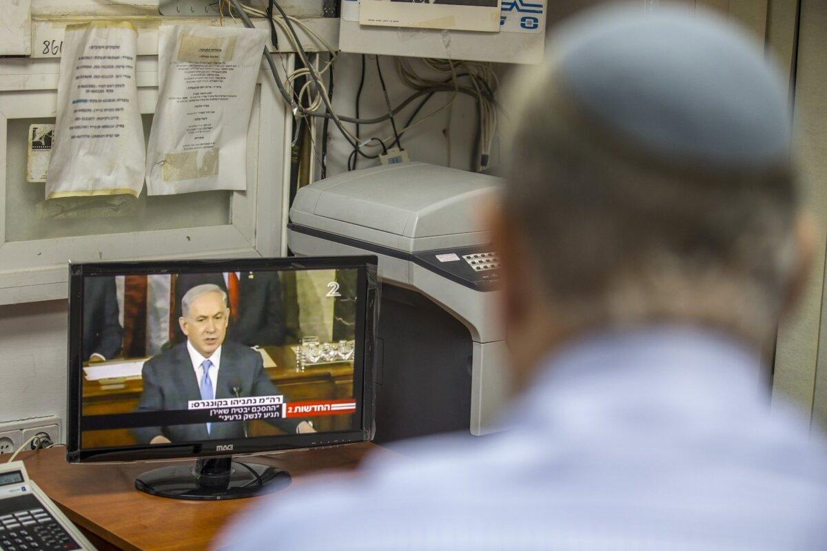 An Israeli man watches a television broadcast of Israeli Prime Minister Benjamin Netanyahu addressing the U.S. Congress at the Capitol in Washington, in the Israeli city of Netanya, on March 3, 2015. (Jack Guez/AFP via Getty Images)