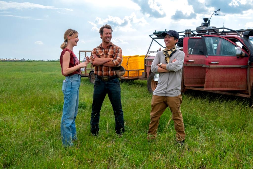 (L–R) Daisy Edgar-Jones, Glen Powell, and director Lee Isaac Chung on the set of “Twisters.” (Universal Pictures)