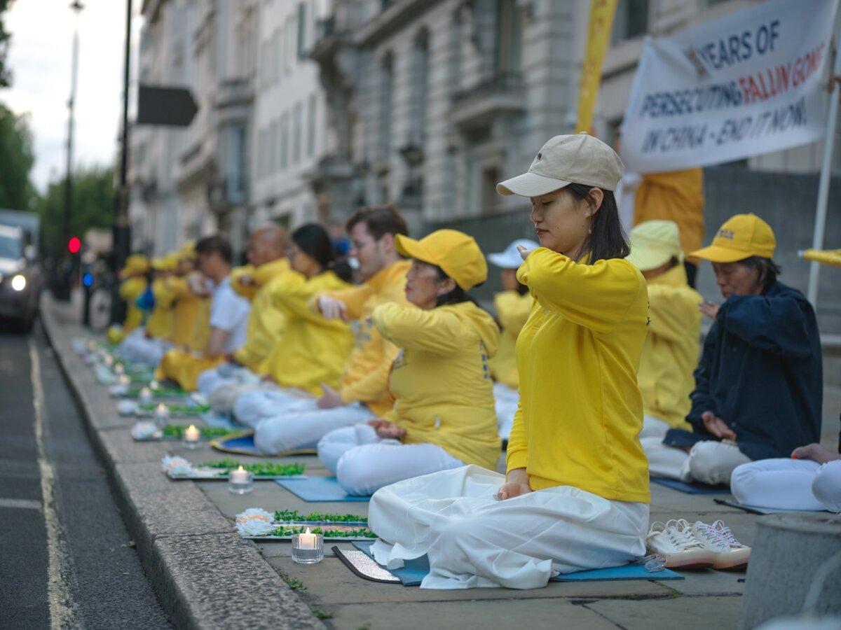 Falun Gong practitioners meditating opposite the Chinese embassy at an event marking 25 years of CCP persecution, in central London, on July 20, 2024. (Yanning Qi/The Epoch Times)