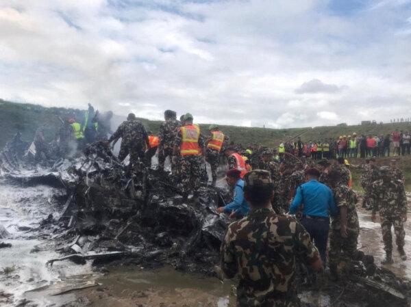 Emergency services work at the accident site of a Saurya Airlines plane that caught fire after skidding off the runway while taking off, in Kathmandu, Nepal, on July 24, 2024. (NepaliArmyHQ via X/Handout via Reuters)