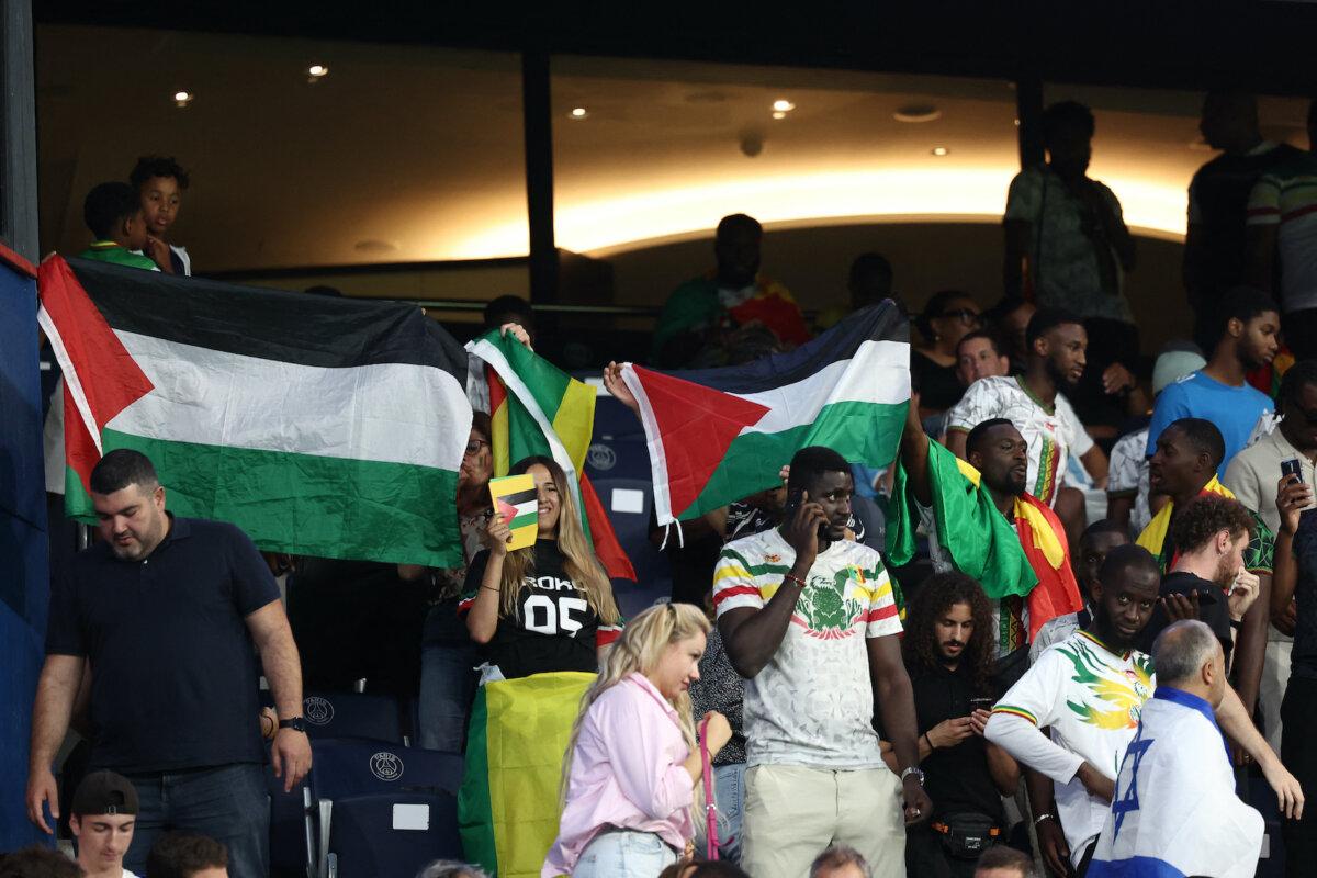 Supporters wave Palestinian flags during the men's group D football match between Mali and Israel during the Paris 2024 Olympic Games at the Parc des Princes in Paris on July 24, 2024. (Franck Fife/AFP via Getty Images)