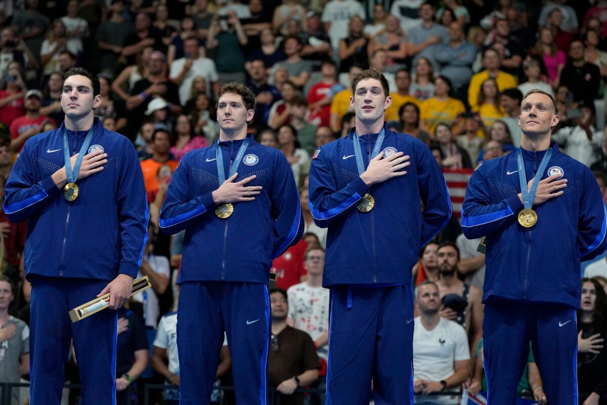 The U.S. men's 4x100-meter freestyle relay team (L to R) Jack Alexy, Chris Guiliano, Hunter Armstrong and Caeleb Dressel stands on the podium after winning the gold medal at the 2024 Summer Olympics in Nanterre, France, on July 27, 2024. (Matthias Schrader/AP Photo)