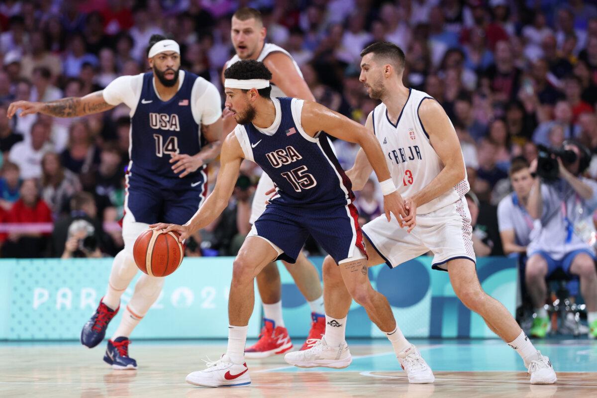 Devin Booker #15 of Team United States drives to the basket against Ognjen Dobric #13 of Team Serbia of the Men's Group Phase-Group C game between Serbia and the United States on day two of the Olympic Games Paris 2024 at Stade Pierre Mauroy in Lille, France on July 28, 2024. (Gregory Shamus/Getty Images)