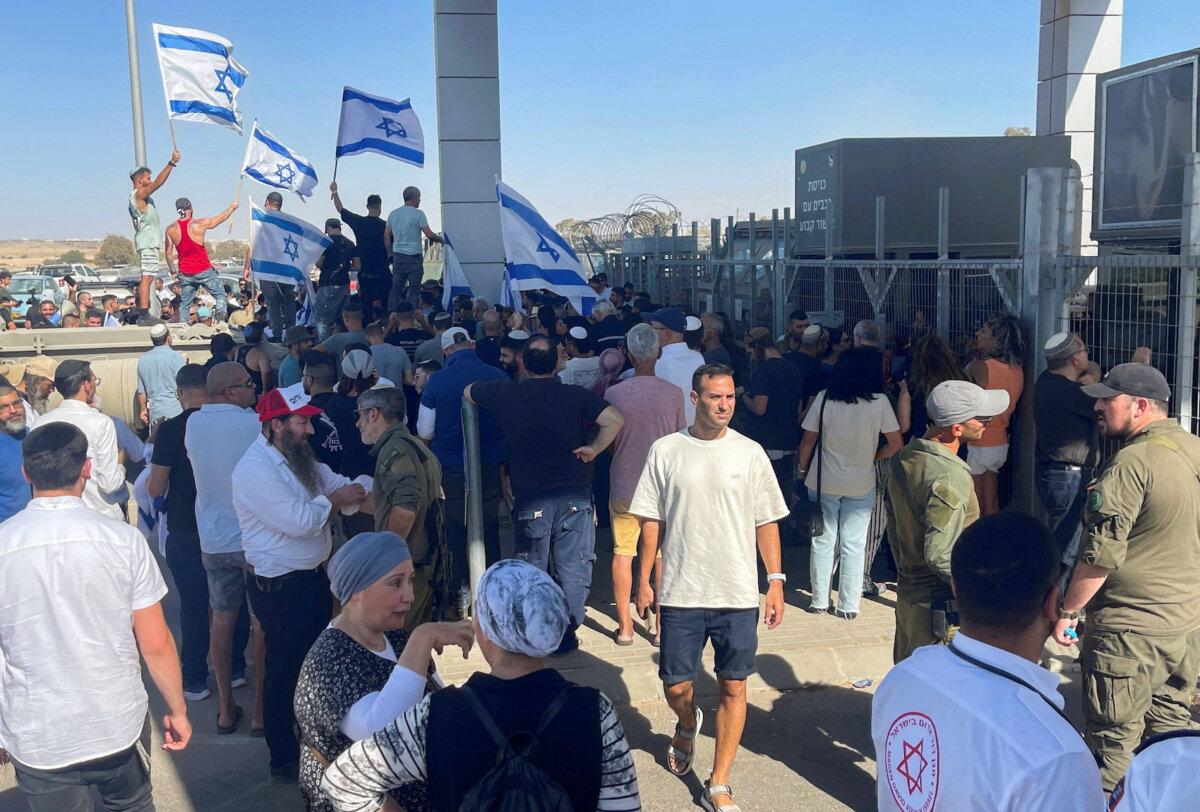 Right-wing protesters wave Israeli flags outside Sde Teiman detention facility after Israeli Military Police arrived at the site as part of an investigation into suspected abuse of a Palestinian detainee, near Beersheba in southern Israel, July 29, 2024. (Jill Gralow/Reuters)