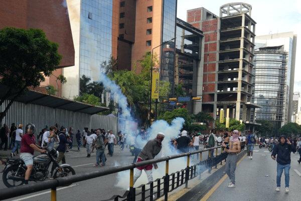 A protester throws back a tear gas canister as Venezuelan opposition supporters protest the country's disputed presidential election results, in Caracas, Venezuela, on July 29, 2024. (Alexandre Meneghini/Reuters)