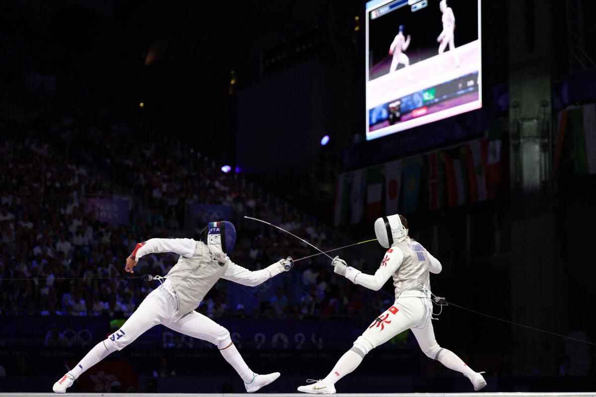 Italy's Filippo Macchi (L) and Hong Kong's Cheung Ka Long compete in the men's foil individual gold medal bout during the Paris 2024 Olympic Games at the Grand Palais in Paris, on July 29, 2024. (Franck Fife/ AFP via Getty Images)