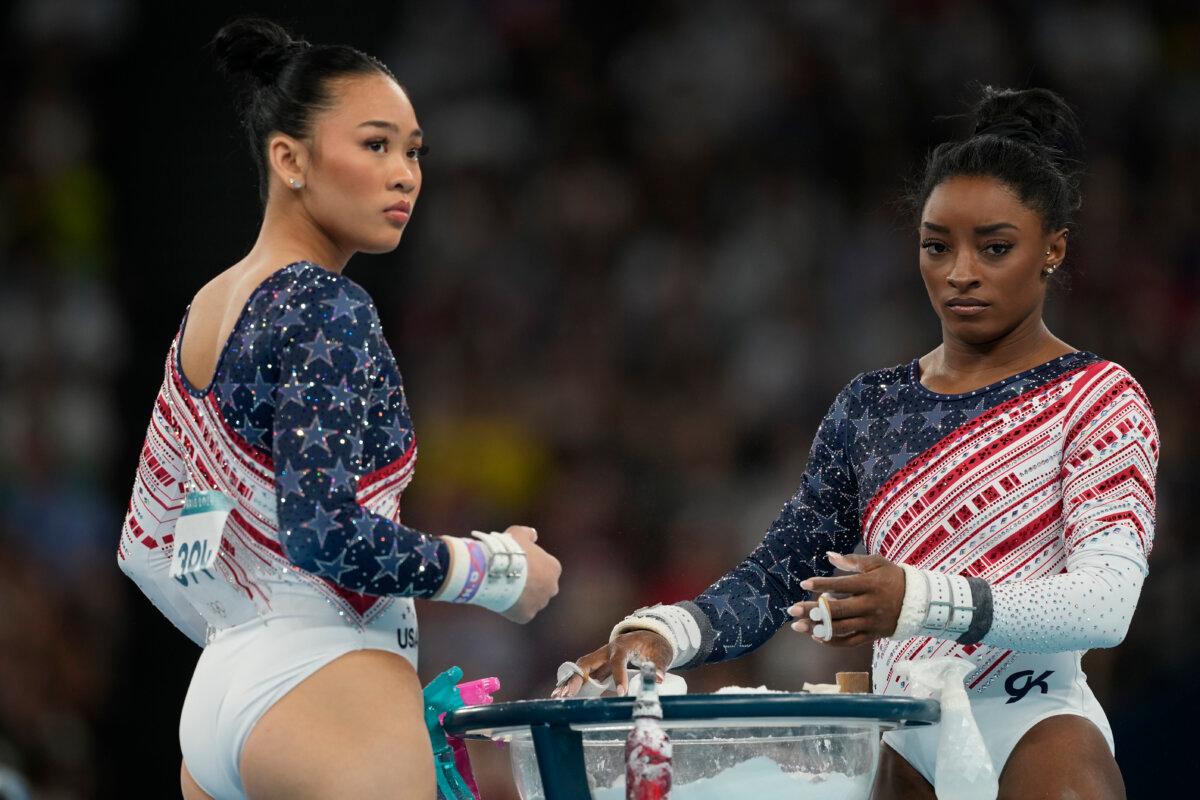 Simone Biles and Suni Lee(L) prepare to performs on the uneven bars during the women's artistic gymnastics team finals round at Bercy Arena in Paris, France, on July 30, 2024. (Charlie Riedel/AP Photo)