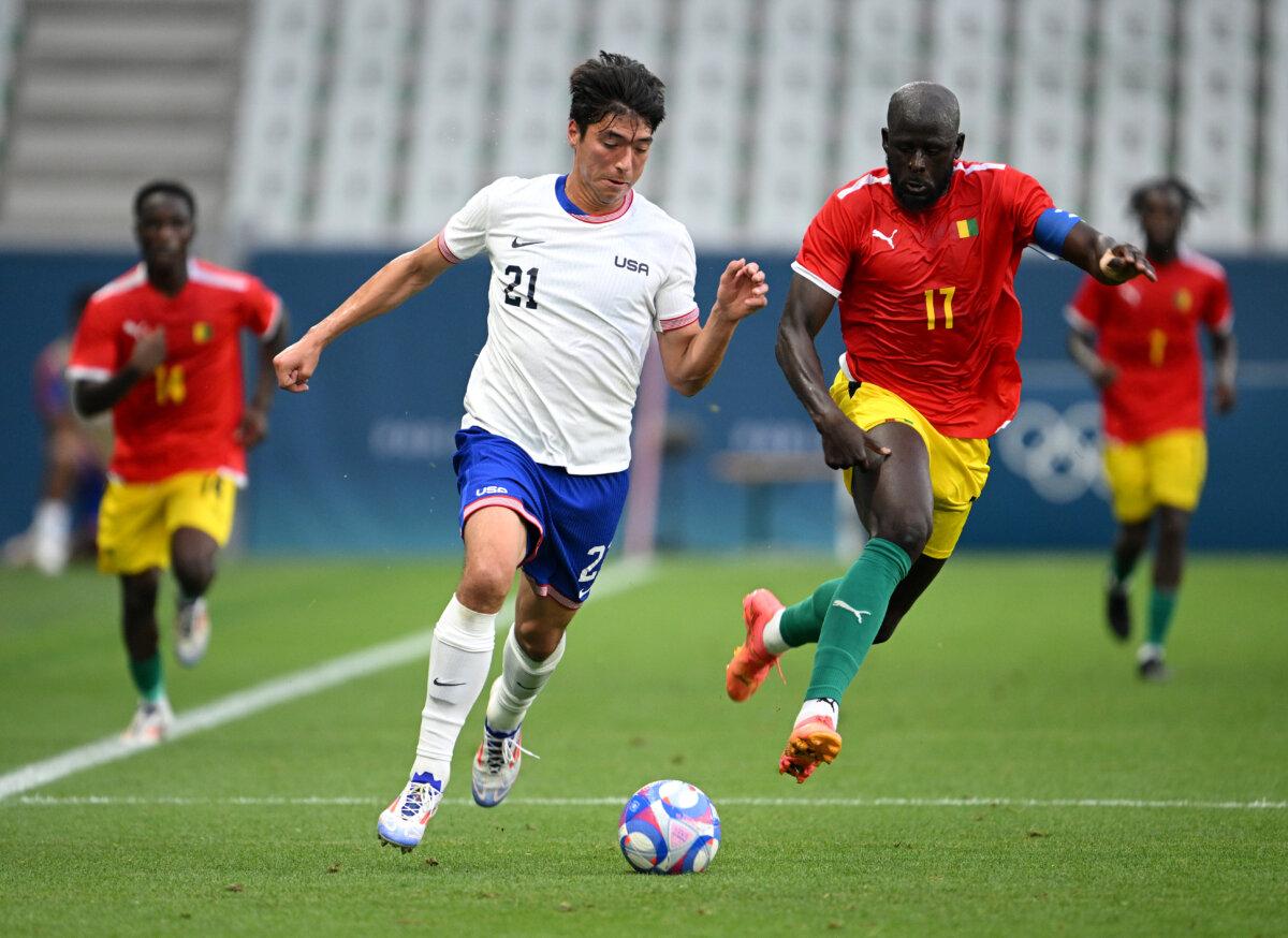 Joshua Atencio #21 of Team USA and Abdoulaye Toure #17 of Team Guinea battle for the ball during the Men's group A match between United States and Guinea during the Olympic Games Paris 2024 at Stade Geoffroy-Guichard in Saint-Etienne, France, on July 30, 2024. (Tullio M. Puglia/Getty Images)