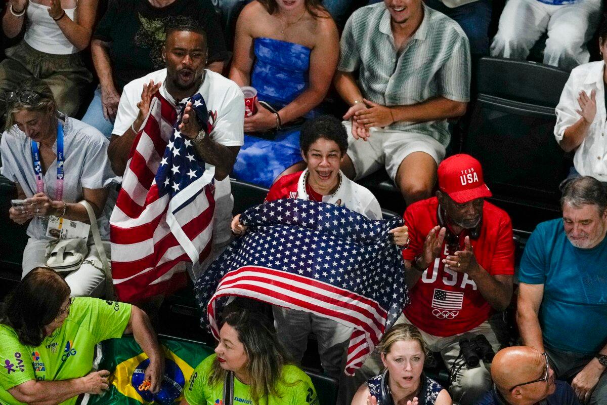 U.S. gymnast Simone Biles's husband Jonathan Owens and her parents Ron and Nellie Biles cheer as she is introduced during the women's artistic gymnastics team finals at the 2024 Summer Olympics in Paris, France, on July 30, 2024. (Morry Gash/AP Photo)
