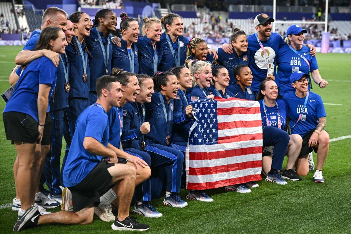 US' players pose with a flag as they celebrate with their bronze medals during the victory ceremony following the women's gold medal rugby sevens match between New Zealand and Canada during the Paris 2024 Olympic Games at the Stade de France in Saint-Denis on July 30, 2024. (Carl De Souza/ AFP via Getty Images)