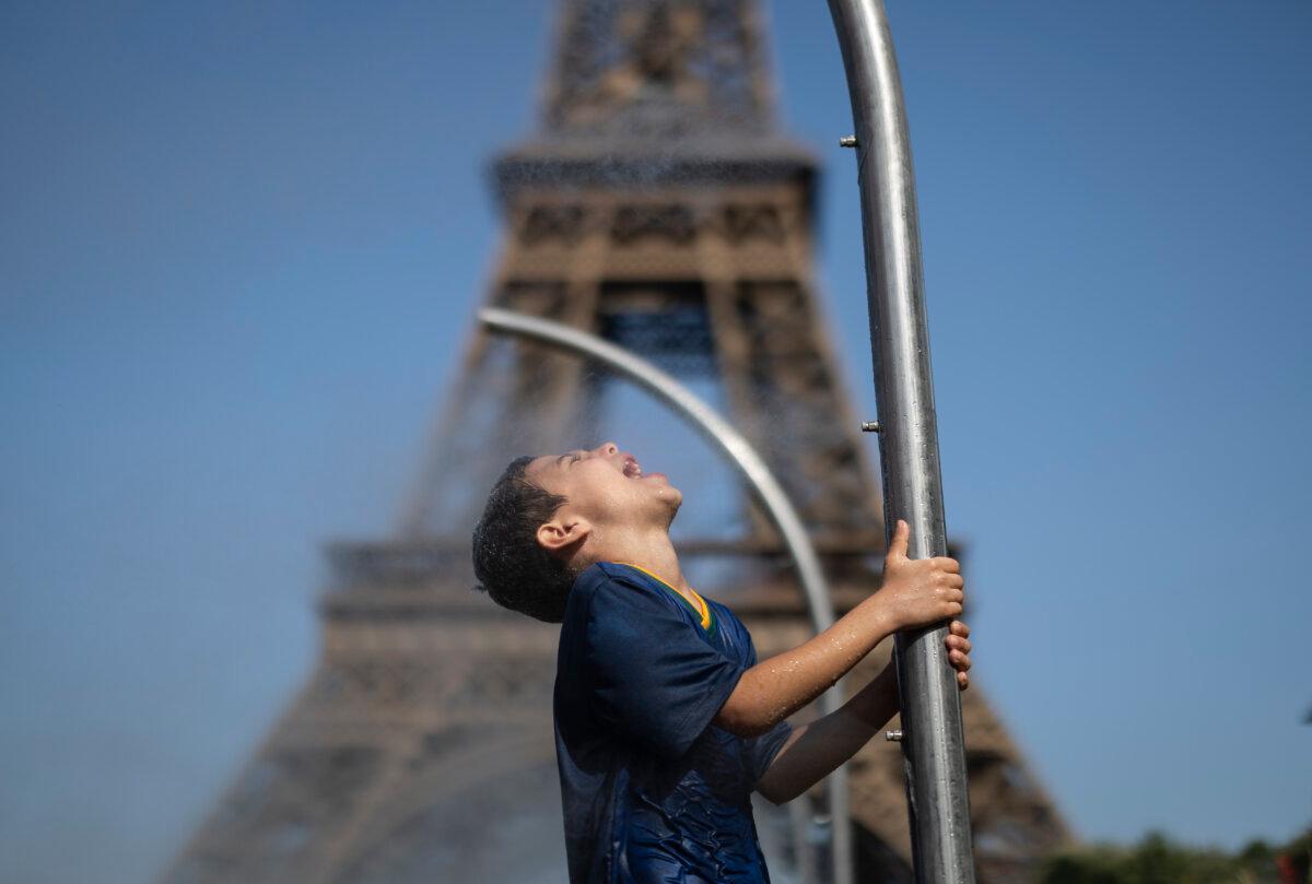 A young Brazilian fan cools off in front of the Eiffel Tower on day four of the Olympic Games Paris 2024 at on July 30, 2024, in Paris, France. (Ryan Pierse/Getty Images)