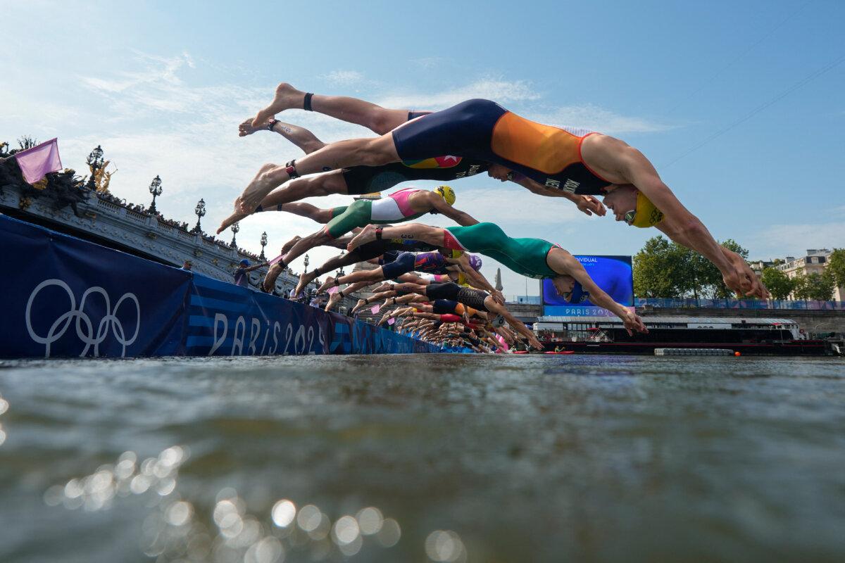 Athletes dive into the Seine river to start the swimming stage of the men's individual triathlon at the Paris 2024 Olympic Games in central Paris on July 31, 2024. (David Goldman/POO / AFP via Getty Images)