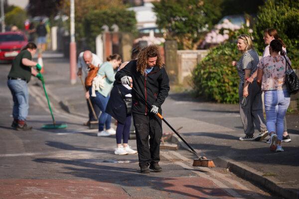 Volunteers sweep Sussex Road in Southport, Merseyside, after police officers suffered serious injuries during violent protests following a vigil for three girls killed in a knife attack on July 31, 2024. (James Speakman/PA Wire)
