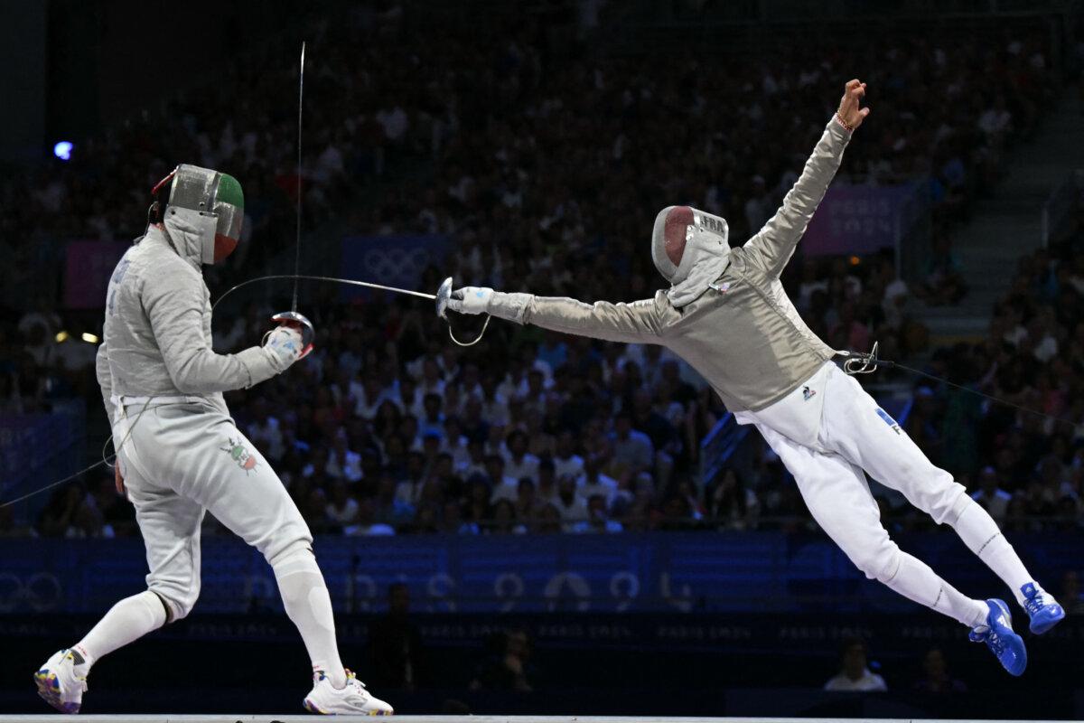 Iran's Mohammad Rahbari Koyakhi (L) competes against France's Sebastien Patrice in the men's sabre team bronze medal bout between Iran and France during the Paris 2024 Olympic Games at the Grand Palais in Paris, on July 31, 2024. (Fabrice Coffrini/AFP via Getty Images)