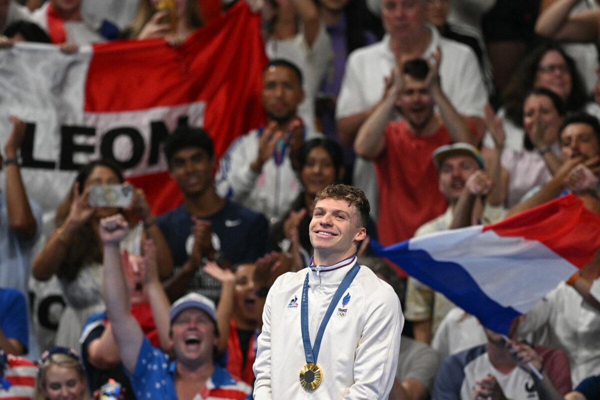 Gold medallist France's Leon Marchand stands on the podium of the men's 200m breaststroke swimming event during the Paris 2024 Olympic Games at the Paris La Defense Arena in Nanterre, west of Paris, on July 31, 2024. (Oli Scarff/AFP via Getty Images)