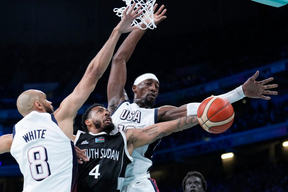 Carlik Jones of South Sudan shoots between Derrick White (8) and Bam Adebayo of the United States in a men's basketball game at the 2024 Summer Olympics in Villeneuve-d'Ascq, France, on July 31, 2024. (Mark J. Terrill/AP Photo)