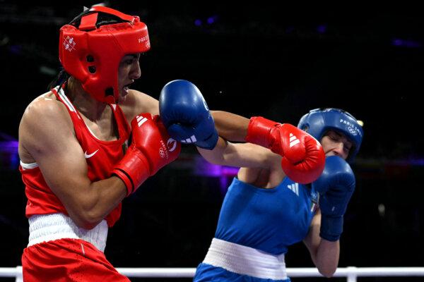 Algeria's Imane Khelif (in red) punches Italy's Angela Carini in the women's 66kg preliminaries round of 16 boxing match during the Paris 2024 Olympic Games at the North Paris Arena, in Villepinte on Aug. 1, 2024. (Mohd Rasfan/AFP via Getty Images)