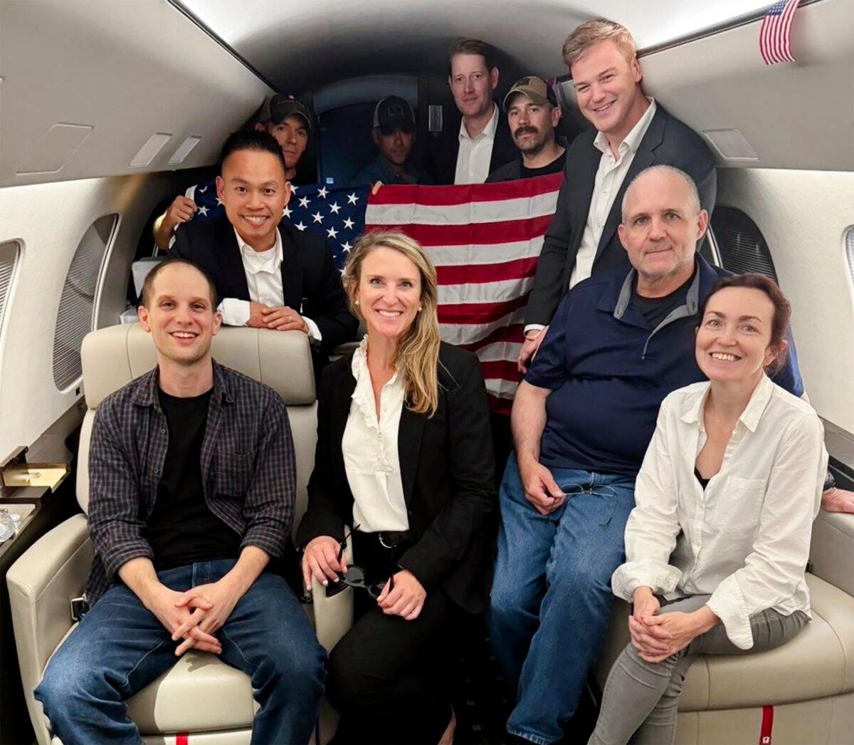 Evan Gershkovich (L), Alsu Kurmasheva (R), and Paul Whelan (2nd R), and others aboard a plane, on Aug. 1, 2024, following their release from Russian captivity. (White House via AP)