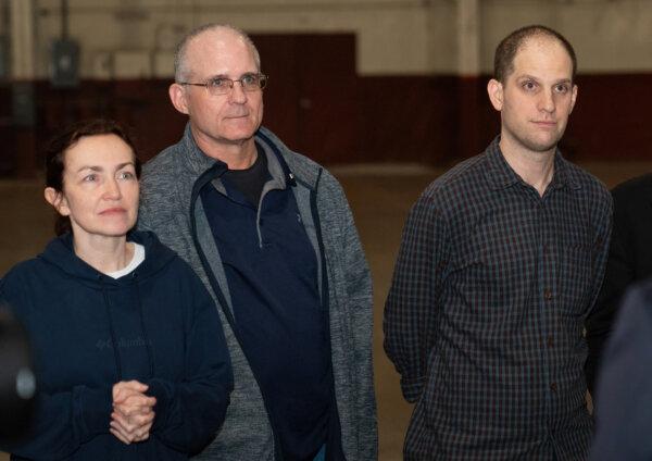 Former prisoners released by Russia, US journalist Evan Gershkovich (R), former US marine Paul Whelan (C), and US-Russian journalist Alsu Kurmasheva (L) stand after landing at Joint Base San Antonio-Kelly Field, Texas, on Aug. 2, 2024. (Suzanne Cordeiro/AFP via Getty Images)