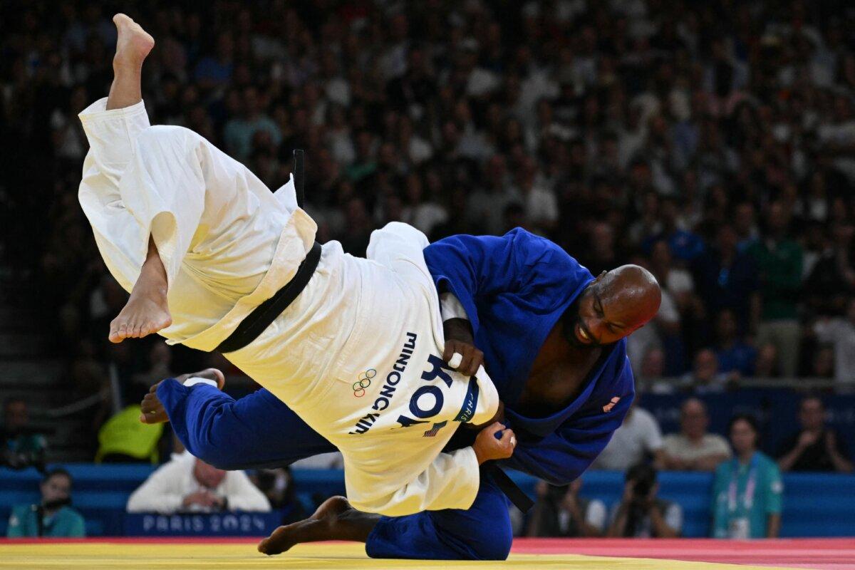 South Korea's Kim Min-jong and France's Teddy Riner (Blue) compete in the judo men's +100kg gold bout of the Paris 2024 Olympic Games at the Champ-de-Mars Arena, in Paris on August 2, 2024. (Luis Robayo/AFP via Getty Images)