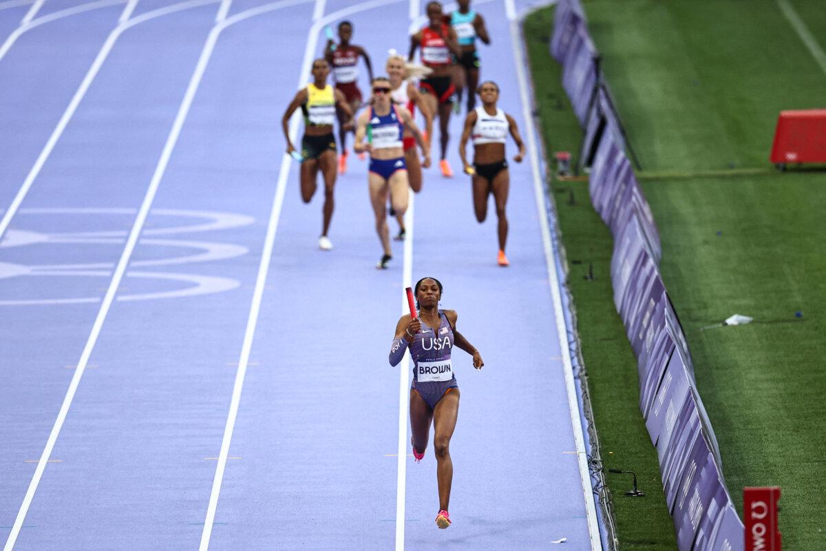 US' Kaylyn Brown runs with the baton in the mixed 4x400m relay heat of the athletics event at the Paris 2024 Olympic Games at Stade de France in Saint-Denis, north of Paris, on August 2, 2024. (Anne-Christine Poujoulat/AFP via Getty Images)