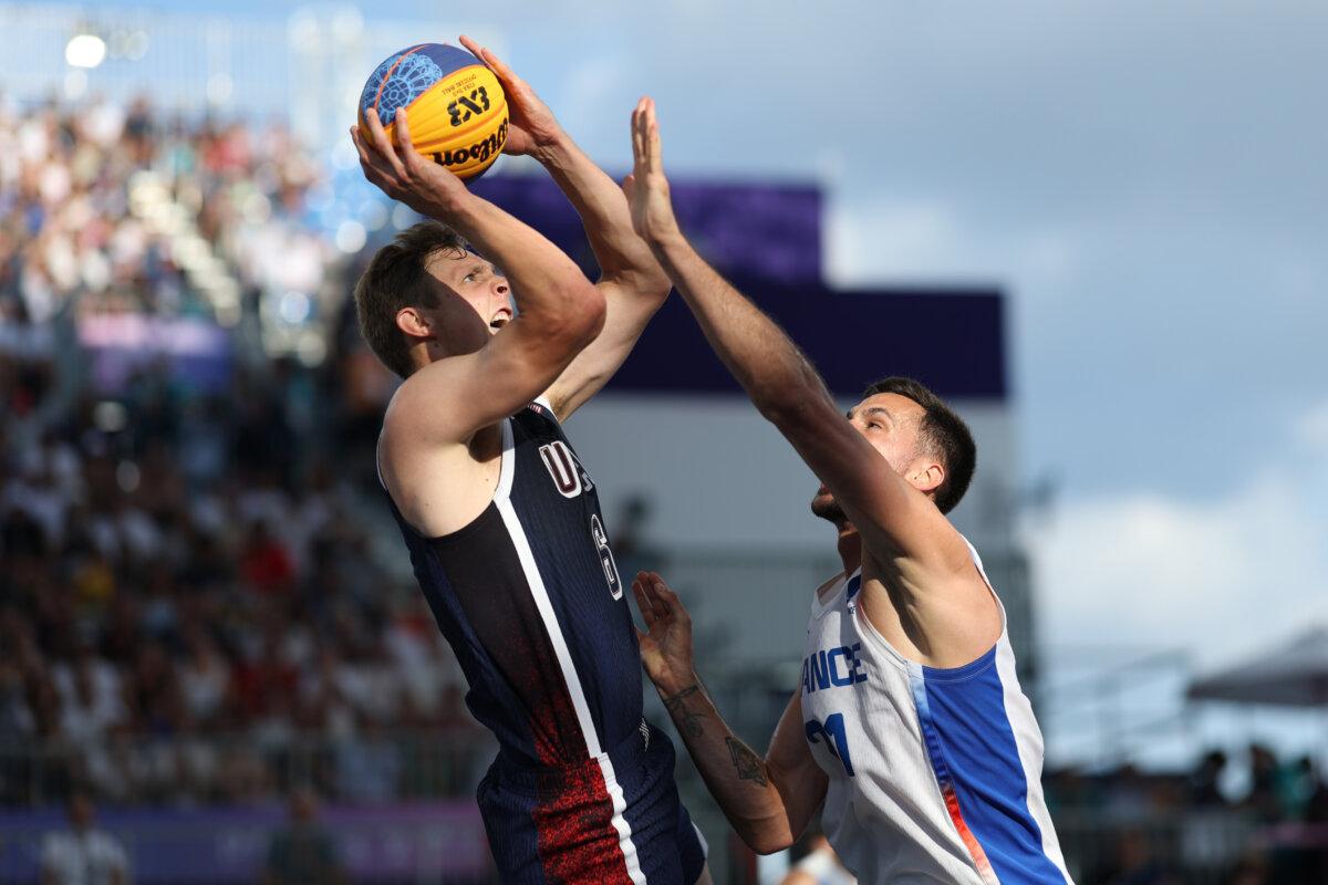 Canyon Barry #6 of Team United States shoots over Franck Seguela #21 of Team France during a Men's 3x3 Basketball Pool Round game between the United States and France on day seven of the Olympic Games Paris 2024 at Esplanade Des Invalides in Paris on August 2, 2024. (Lintao Zhang/Getty Images)