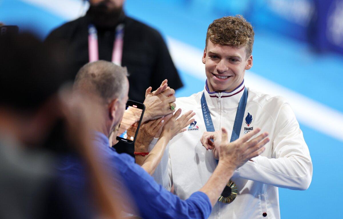 Gold Medalist Leon Marchand of Team France interacts with fans following the Swimming medal ceremony after the Men's 200m Individual Medley Final on day seven of the Olympic Games Paris 2024 at Paris La Defense Arena in Nanterre, France on August 2, 2024. (Quinn Rooney/Getty Images)