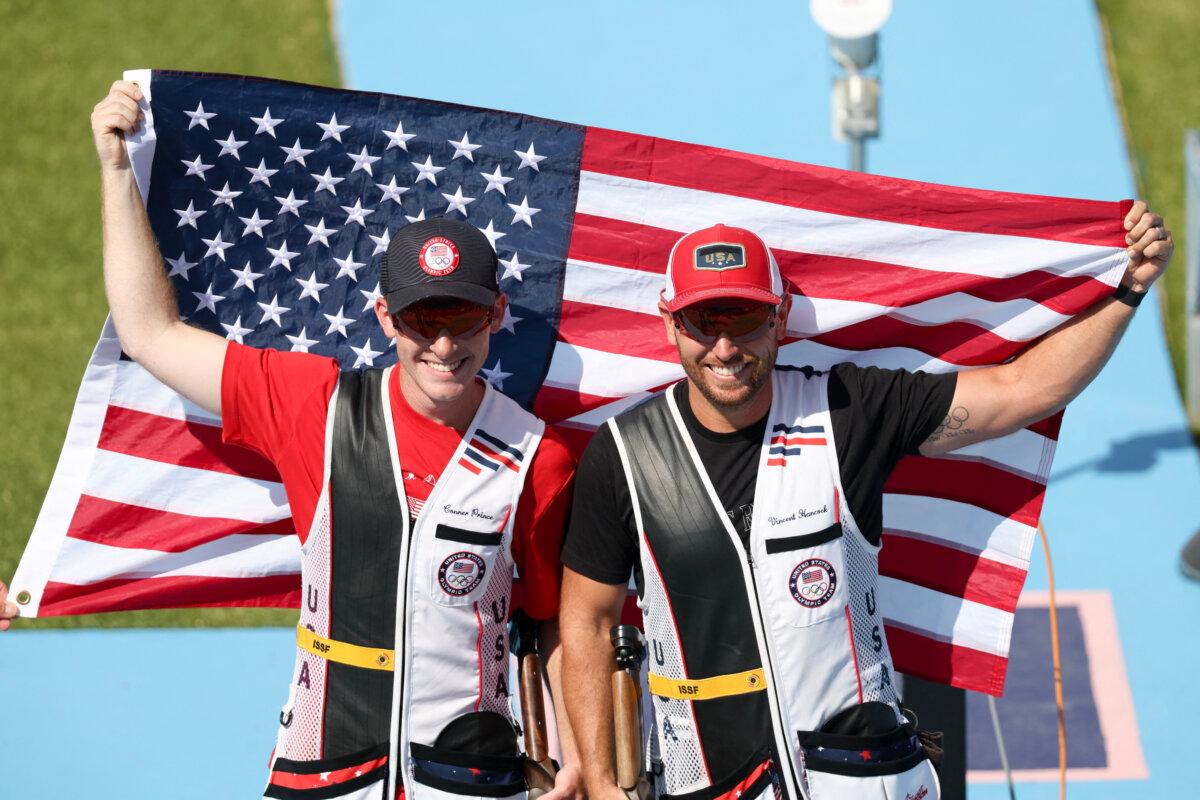 Team USA's gold medallist Vincent Hancock and US silver medallist US Conner Lynn Prince (L) pose withthe US flag after the Skeet men's Final during the Paris 2024 Olympic Games at Chateauroux Shooting Centre on August 3, 2024. (Alain Jocard/AFP via Getty Images)