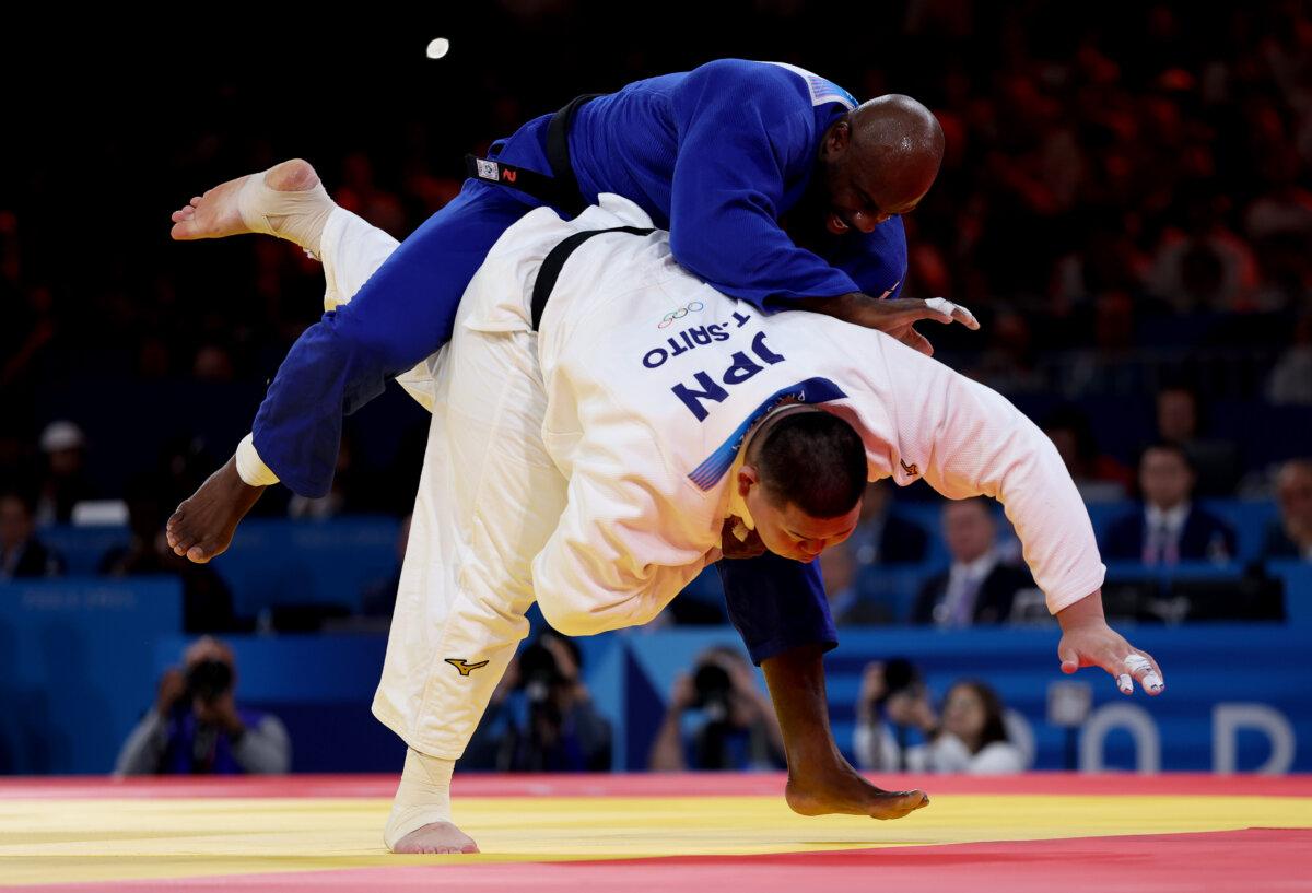 Tatsuru Saito (white) of Team Japan and Teddy Riner (blue) of Team France compete in the Men +90kg during the Judo Mixed Team Final on day eight of the Olympic Games Paris 2024 at Champs-de-Mars Arena in Paris on August 3, 2024. (Sarah Stier/Getty Images)
