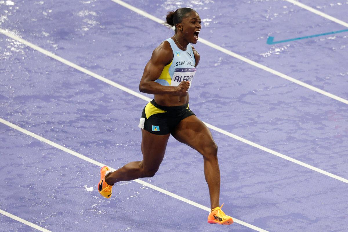 Saint Lucia's Julien Alfred celebrates winning the women's 100m final of the athletics event at the Paris 2024 Olympic Games at Stade de France in Saint-Denis, north of Paris, on August 3, 2024. (Odd Andersen / AFP via Getty Images)