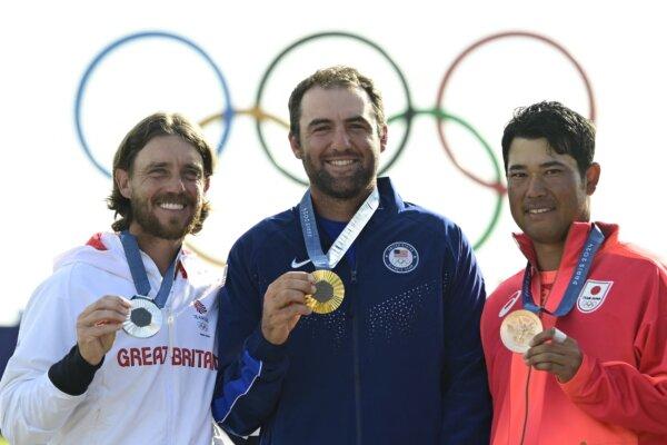 (L-R) Silver medallist Britain's Thomas Fleetwood, gold medallist US' Scottie Scheffler and bronze medallist Japan's Hideki Matsuyama pose for pictures after round 4 of the men’s golf individual stroke play of the Paris 2024 Olympic Games in Paris on Aug. 4, 2024. (John MacDougall/AFP)