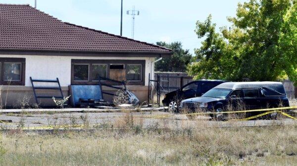 A hearse and debris sit behind the Return to Nature Funeral Home in Penrose, Colo., on Oct. 5, 2023. (Jerilee Bennett/The Gazette via AP)