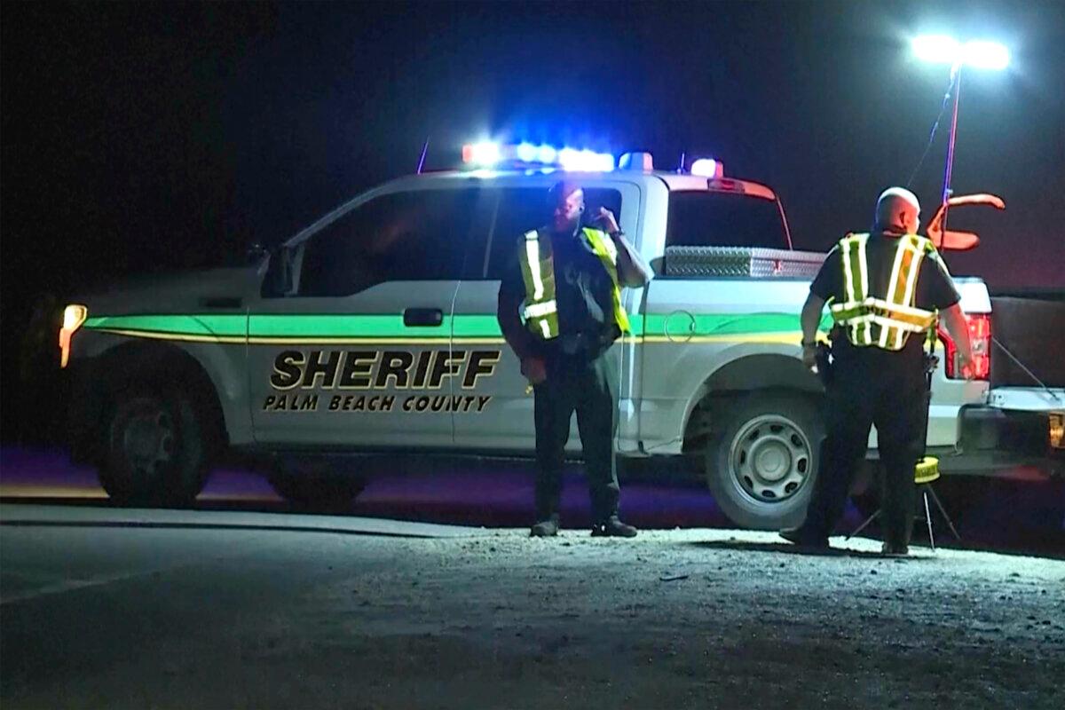 A Palm Beach County, Fla., sheriff vehicle at the scene where nine people died when an overloaded SUV went out of control on Hatton Highway near Belle Glade, hit a guardrail and flipped upside down into a canal on Aug. 5, 2024. (WPTV via AP)
