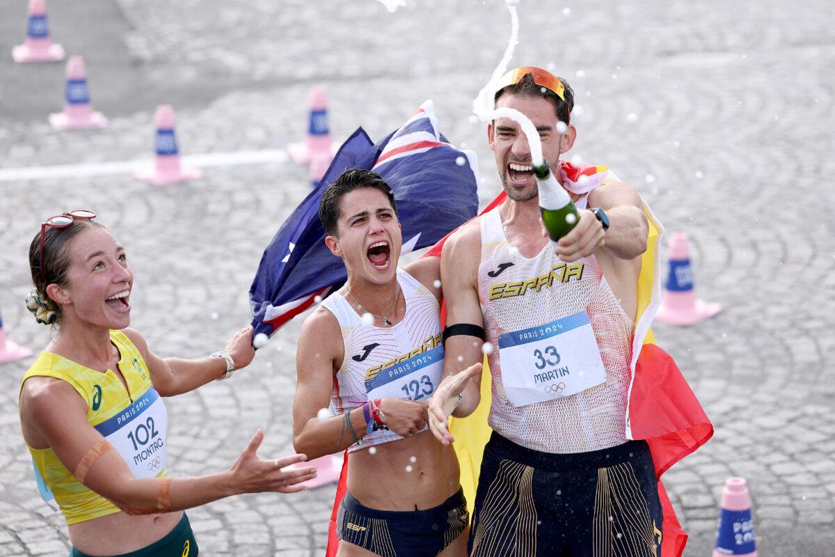 Jemima Montag of Team Australia, Maria Perez, and Alvaro Martin of Team Spain celebrate after crossing the finish line during the mixed marathon race Walk Relay on day twelve of the Olympic Games at Stade de France in Paris on Aug. 7, 2024. (Luke Hales/Getty Images)