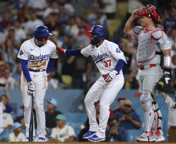 Teoscar Hernández (37) of the Los Angeles Dodgers celebrates his solo home run with Freddie Freeman (5) in front of J.T. Realmuto (10) of the Philadelphia Phillies, to trail 4–2 , during the eighth inning in Los Angeles on Aug. 6, 2024. (Harry How/Getty Images)