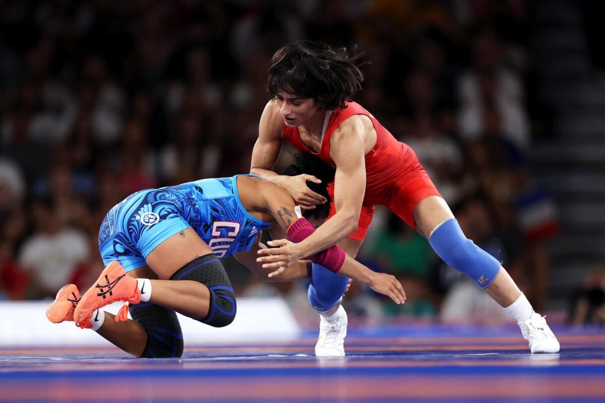 Vinesh Vinesh of Team India (red) competes with Yusneylis Guzman Lopez of Team Cuba (blue) during the Wrestling women's freestyle 50kg semifinal on day eleven of the Olympic Games at Champs-de-Mars Arena in Paris, France, on Aug. 6, 2024. (Sarah Stier/Getty Images)