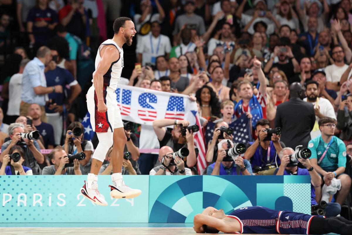 Stephen Curry of Team United States celebrates while Aleksa Avramovic of Team Serbia reacts after Team United States' victory against Team Serbia during a men's basketball semifinals match on day 13 of the Olympic Games at Bercy Arena in Paris on Aug. 8, 2024. (Ezra Shaw/Getty Images)