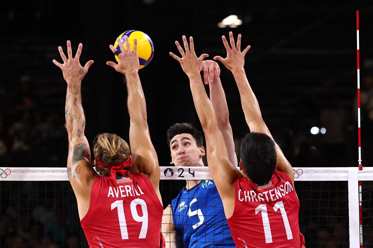 Alessandro Michieletto of Team Italy attacks the net against Taylor Averill and Micah Christenson of Team United States during a men's bronze medal match between Team Italy and Team United States on day fourteen of the Olympic Games in Paris on Aug. 9, 2024. (Buda Mendes/Getty Images)