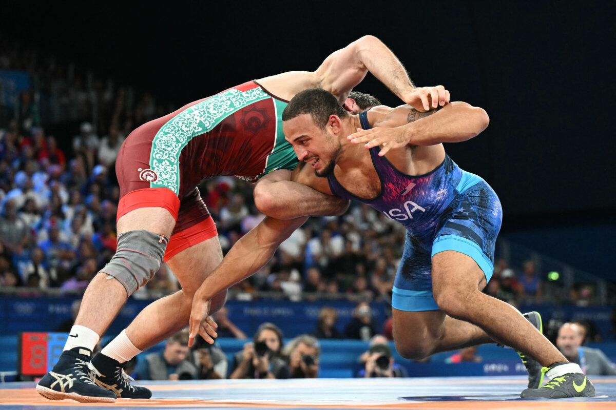Uzbekistan's Javrail Shapiev (red) wrestles Team USA's Aaron Marquel Brooks (blue) in their men's freestyle 86kg wrestling bronze medal match at the Champ-de-Mars Arena during the Paris 2024 Olympic Games, in Paris on Aug. 9, 2024. (Punit Paranjpe/ AFP via Getty Images)