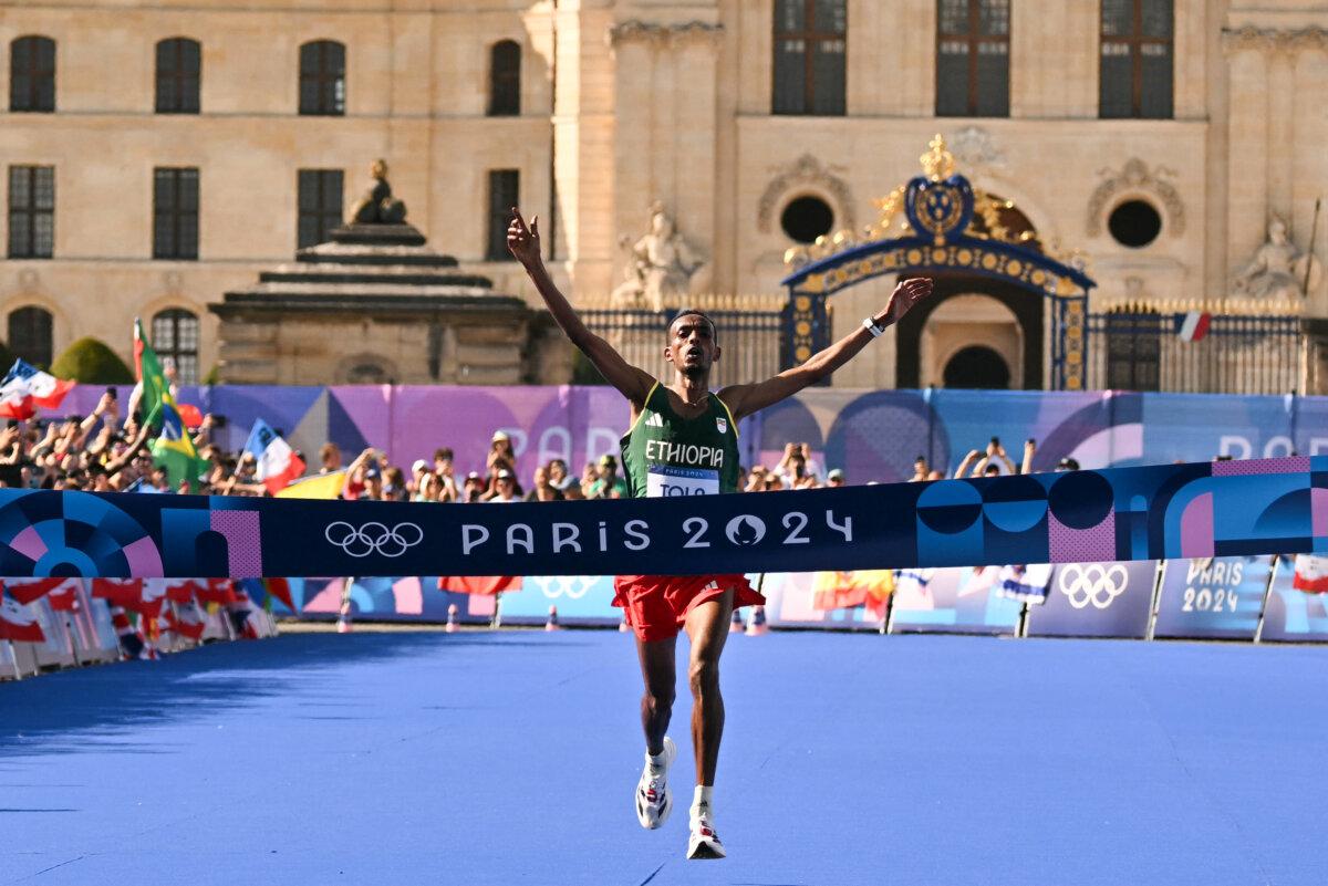 Ethiopia's Tamirat Tola crosses the finish line to win the men's marathon of the athletics event at the Olympic Games at Invalides in Paris on Aug. 10, 2024. (Andrej Isakovic/AFP via Getty Images)