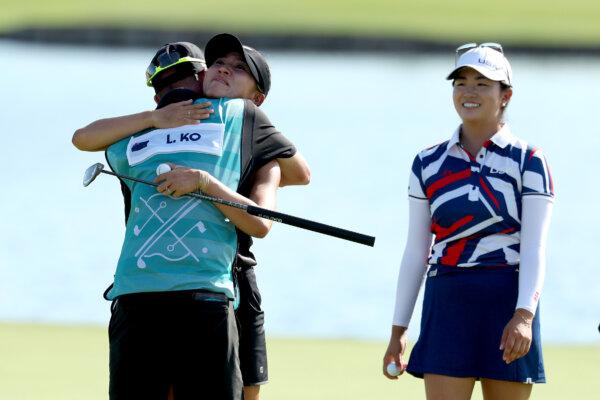 Lydia Ko of Team New Zealand embraces her caddie, Paul Cormack on the 18th green following victory on Day Four of the Women's Individual Stroke Play on day fifteen of the Olympic Games Paris 2024 in Paris on August 10, 2024. (Kevin C. Cox/Getty Images)