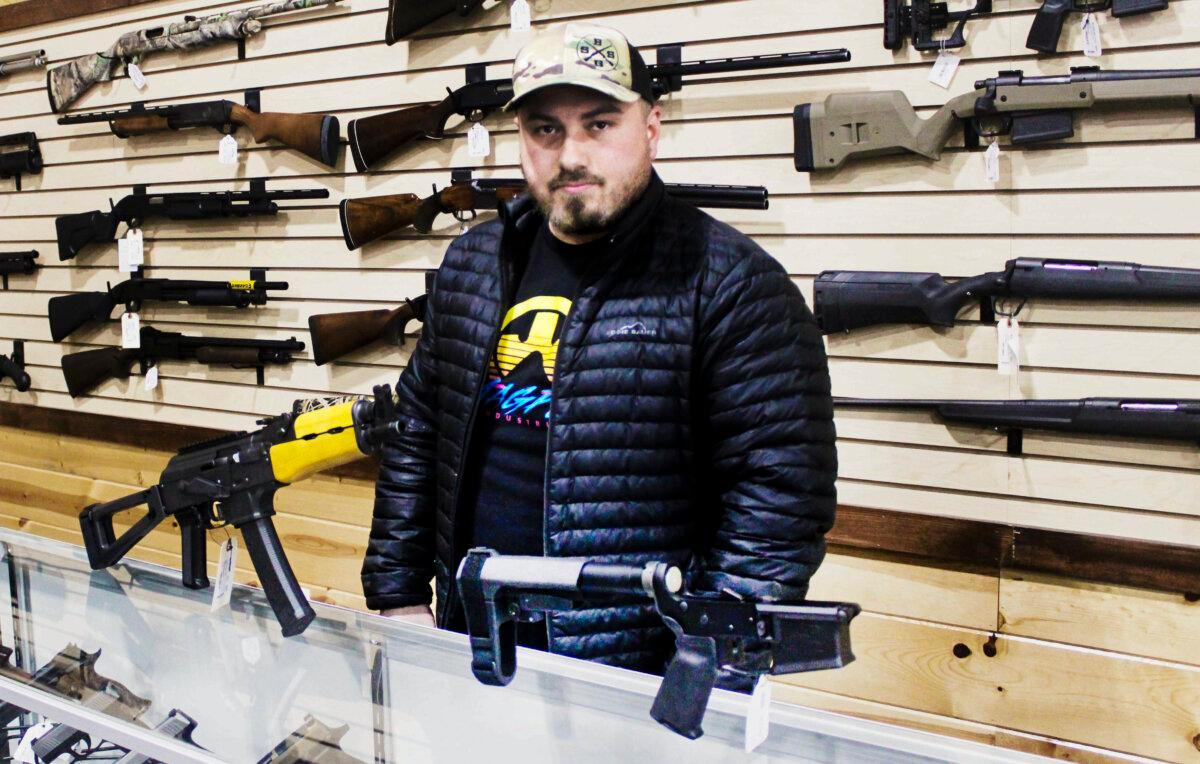 Justin Barrett, owner of Barrett Outdoors in Durant, Okla., displays some pistol-stabilizing braces. (Michael Clements/The Epoch Times)