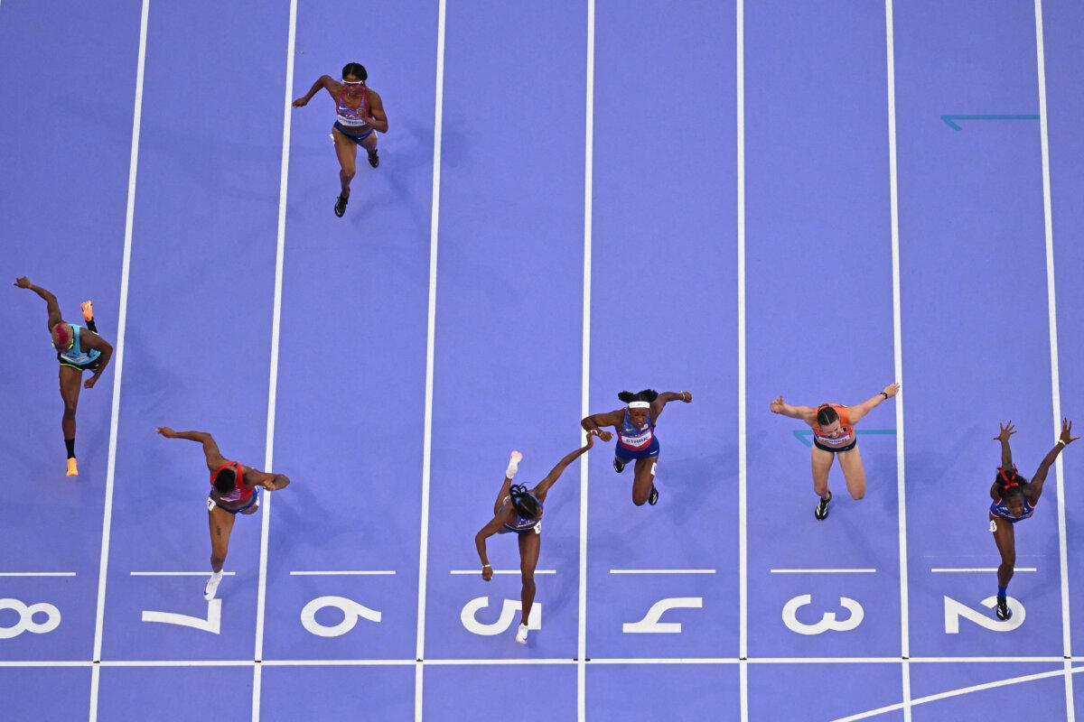 Team USA's Masai Russell (5) crosses the finish line in the women's 100-meter hurdles final of the athletics event at the Paris 2024 Olympic Games at Stade de France in Saint-Denis, north of Paris, on Aug. 10, 2024. (Jewel Samad/AFP via Getty Images)