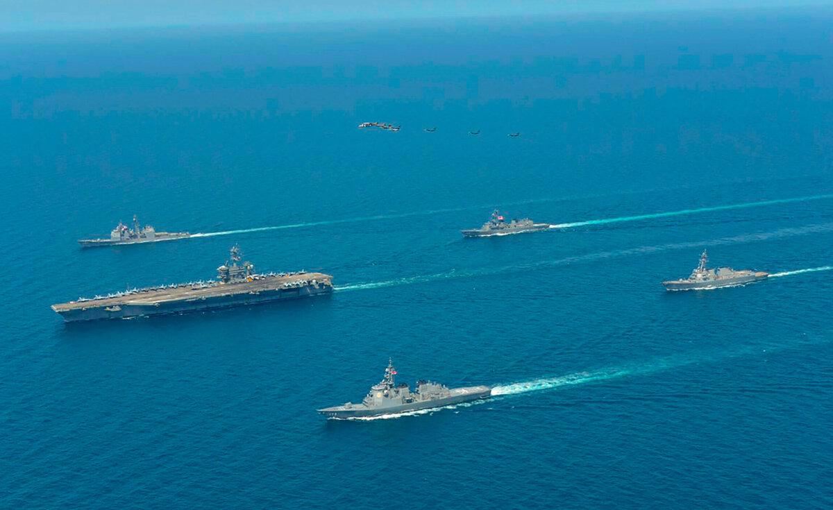 USS Abraham Lincoln (L), and JS Kongo (front), sail in formation during a U.S.–Japan bilateral exercise at the Sea of Japan on April 12, 2022. (Japan Maritime Self-Defense Force via AP)