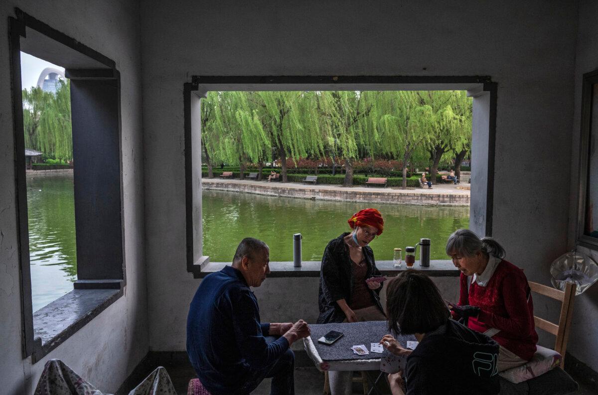 People play cards at a local park in Beijing on Apr. 18, 2024. (Kevin Frayer/Getty Images)