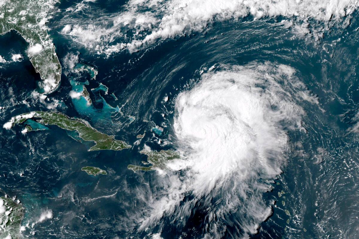 A satellite image shows Hurricane Ernesto northwest of San Juan, Puerto Rico, and moving over open waters, at at 4 p.m ET on Aug. 14, 2024. (NOAA via AP)