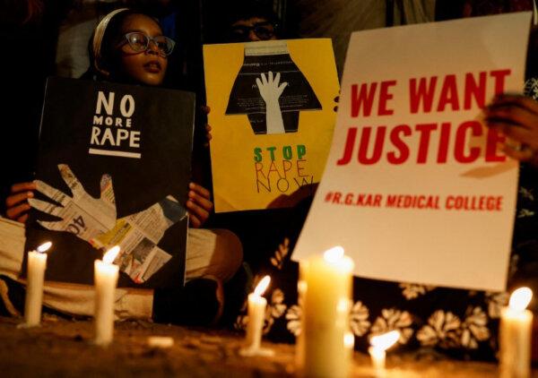 People hold posters during a vigil condemning the rape and murder of a trainee doctor at a government-run hospital in Kolkata, on a street in Mumbai, India, on Aug. 14, 2024. (Francis Mascarenhas/Reuters)