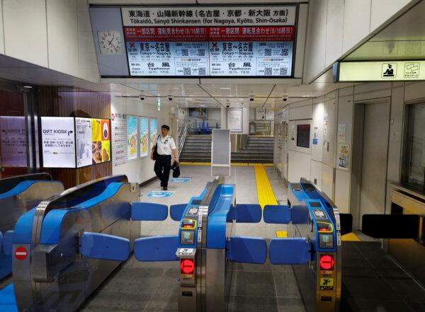 A railway staffer makes his way to a closed turnstile as the high-speed 'Shinkansen' bullet train services between Tokyo and Nagoya are cancelled due to Typhoon Ampil at a train station in Tokyo, Japan Aug. 16, 2024. (Reuters/Kim Kyung-Hoon)